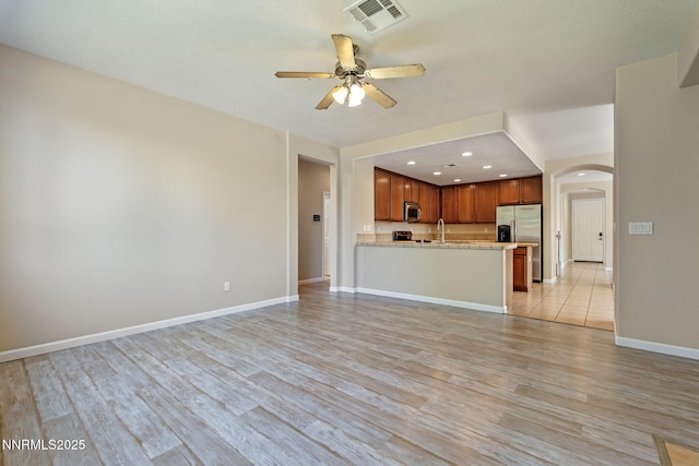 7121 Jermann Dr, Sparks, NV 89436 - unfurnished living room with arched walkways, light wood-type flooring, a ceiling fan, and recessed lighting