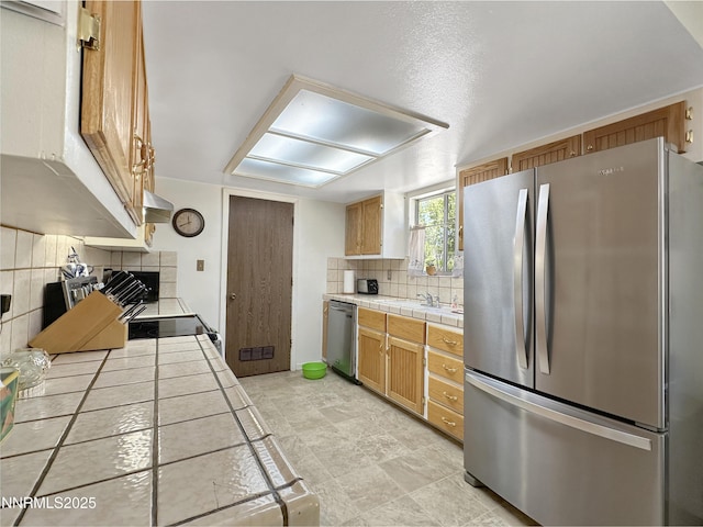 1331 Stephanie Way, Minden, NV 89423 - kitchen featuring appliances with stainless steel finishes, tile counters, tasteful backsplash, ventilation hood, and a fireplace