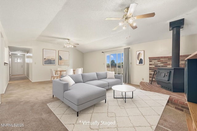 1331 Stephanie Way, Minden, NV 89423 - living room featuring a ceiling fan, a wood stove, light colored carpet, lofted ceiling, and a textured ceiling