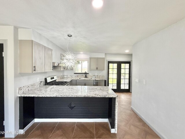 603 Camelot Way, Winnemucca, NV 89445 - kitchen featuring a sink, appliances with stainless steel finishes, baseboards, a peninsula, and light stone countertops