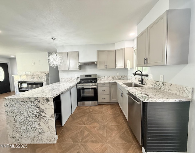 603 Camelot Way, Winnemucca, NV 89445 - kitchen with stainless steel appliances, a sink, gray cabinets, a peninsula, and light stone countertops