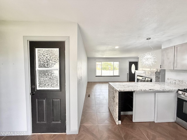 603 Camelot Way, Winnemucca, NV 89445 - kitchen with stainless steel gas range oven, a peninsula, baseboards, open floor plan, and open shelves