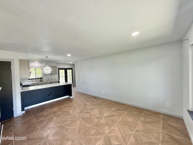 603 Camelot Way, Winnemucca, NV 89445 - unfurnished living room with a textured ceiling, recessed lighting, baseboards, and a sink