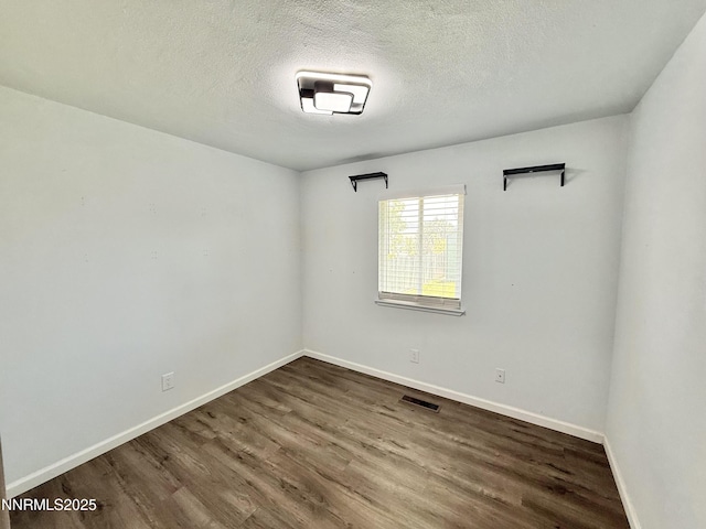 603 Camelot Way, Winnemucca, NV 89445 - spare room featuring dark wood-style floors, baseboards, and a textured ceiling