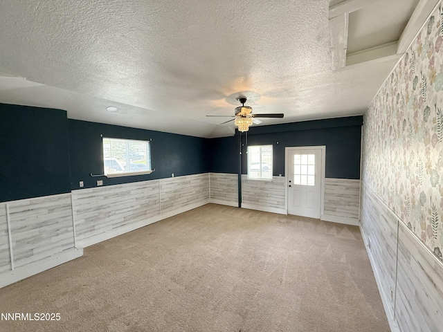 603 Camelot Way, Winnemucca, NV 89445 - unfurnished room with wainscoting, carpet floors, ceiling fan, a textured ceiling, and wallpapered walls