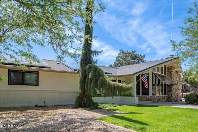 5000 Saint Andrews Dr, Reno, NV 89502 - ranch-style home featuring a front lawn, roof mounted solar panels, brick siding, and stone siding