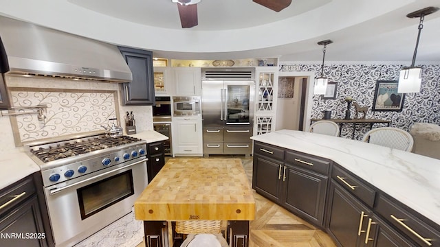 5000 Saint Andrews Dr, Reno, NV 89502 - kitchen with built in appliances, wall chimney exhaust hood, ceiling fan, wallpapered walls, and decorative backsplash
