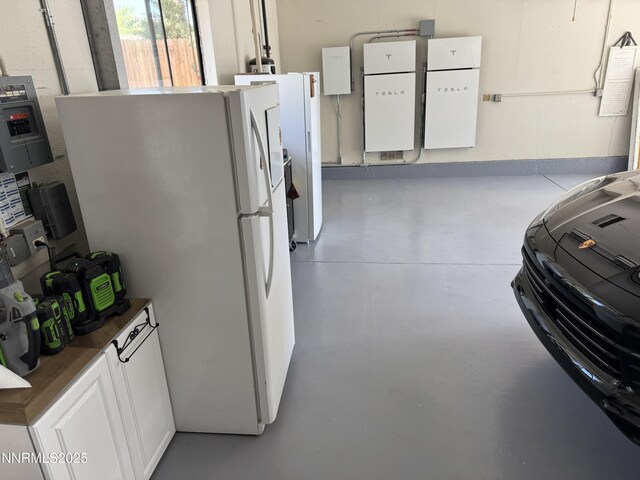 5000 Saint Andrews Dr, Reno, NV 89502 - interior space with concrete floors, freestanding refrigerator, white cabinetry, and dark countertops