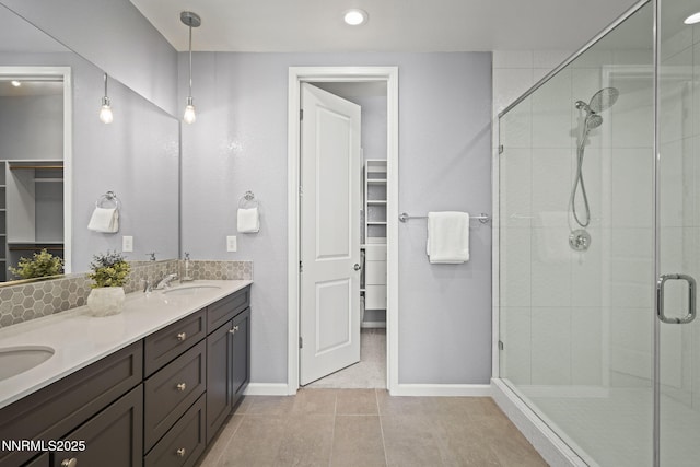 9192 Graycliff Ln, Reno, NV 89523 - bathroom with a walk in closet, double vanity, a stall shower, baseboards, and tile patterned floors