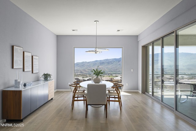 9192 Graycliff Ln, Reno, NV 89523 - dining room featuring a chandelier, light wood finished floors, a mountain view, and baseboards