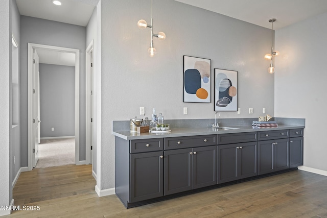 9192 Graycliff Ln, Reno, NV 89523 - indoor wet bar featuring light wood-type flooring, baseboards, and hanging light fixtures