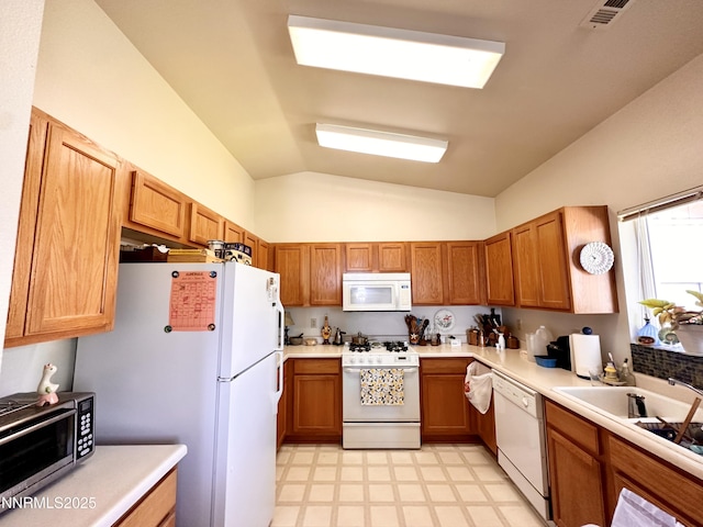 1171 White Oak Loop, Minden, NV 89423 - kitchen featuring white appliances, light flooring, vaulted ceiling, light countertops, and brown cabinets