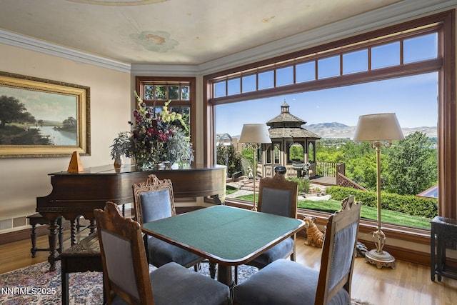 745 California Ave, Reno, NV 89509 - dining space with healthy amount of natural light, a mountain view, crown molding, and wood finished floors