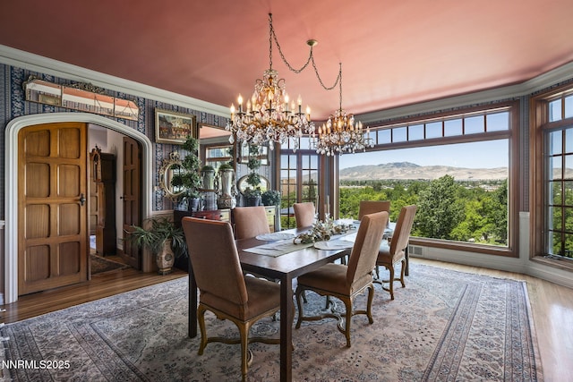 745 California Ave, Reno, NV 89509 - dining space with a chandelier, arched walkways, wood finished floors, ornamental molding, and a mountain view