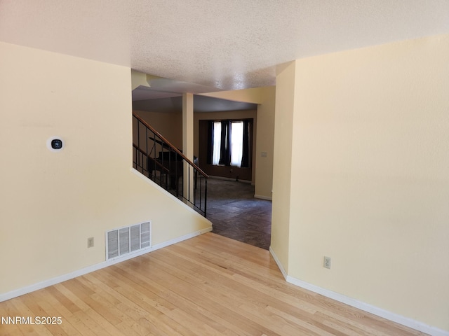 285 Lemming Dr, Reno, NV 89523 - empty room with a textured ceiling, stairway, baseboards, and wood finished floors