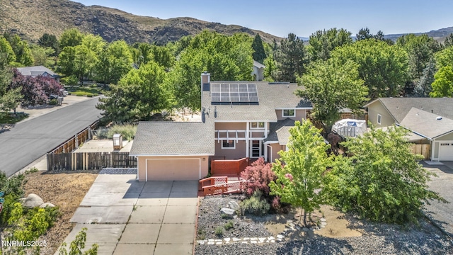 285 Lemming Dr, Reno, NV 89523 - view of front of home with concrete driveway, roof mounted solar panels, a chimney, an attached garage, and stucco siding