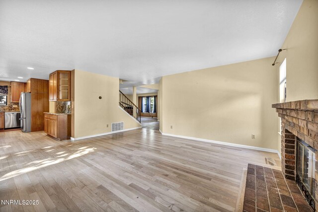 285 Lemming Dr, Reno, NV 89523 - unfurnished living room with a brick fireplace, plenty of natural light, stairs, light wood-type flooring, and recessed lighting