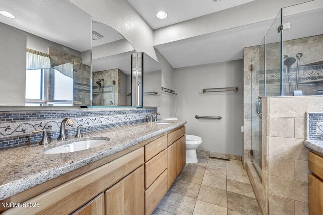 285 Lemming Dr, Reno, NV 89523 - full bathroom featuring double vanity, a stall shower, tasteful backsplash, and stone finish floors