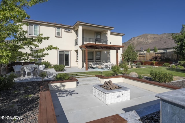 2780 Trail Rider Dr, Reno, NV 89521 - rear view of property with a balcony, a fire pit, a patio, and stucco siding