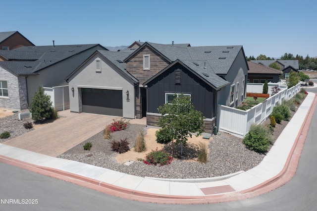 611 Camargue Trl, Reno, NV 89511 - view of front facade with board and batten siding, a garage, decorative driveway, roof with shingles, and stone siding