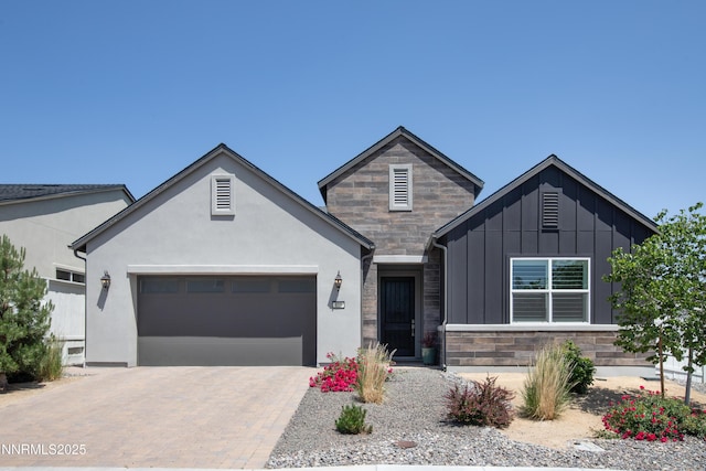 611 Camargue Trl, Reno, NV 89511 - view of front of home with a garage, stone siding, board and batten siding, and decorative driveway