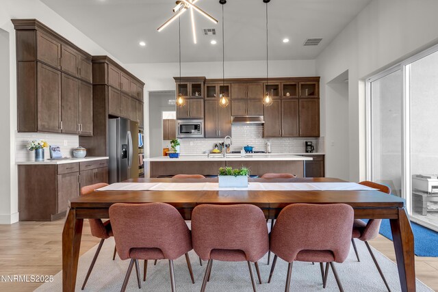 611 Camargue Trl, Reno, NV 89511 - kitchen with appliances with stainless steel finishes, a center island with sink, under cabinet range hood, light countertops, and recessed lighting