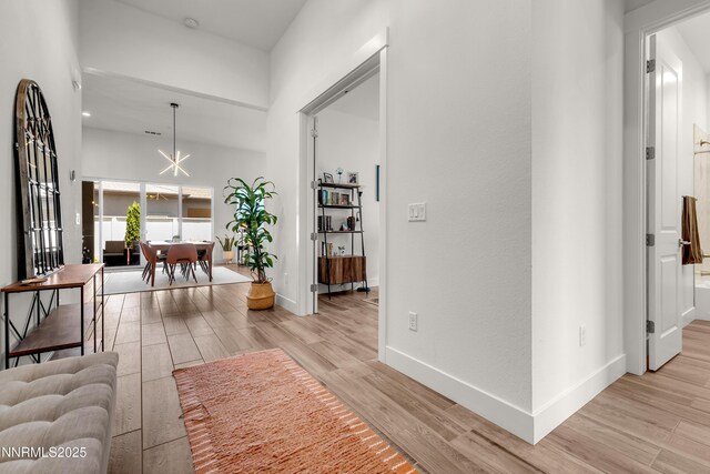 611 Camargue Trl, Reno, NV 89511 - corridor with light wood-type flooring, baseboards, and a chandelier