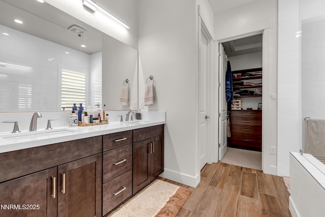 611 Camargue Trl, Reno, NV 89511 - bathroom featuring wood finished floors, double vanity, a spacious closet, recessed lighting, and baseboards