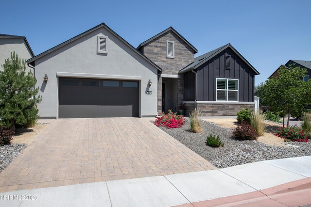 611 Camargue Trl, Reno, NV 89511 - view of front of house with board and batten siding, an attached garage, decorative driveway, and stone siding