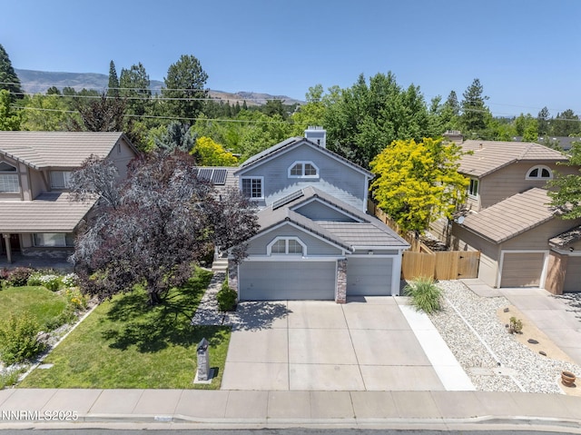 6055 Stonecreek Dr, Reno, NV 89511 - view of front facade with driveway, a mountain view, and an attached garage