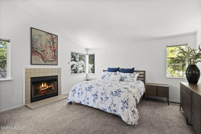 6055 Stonecreek Dr, Reno, NV 89511 - carpeted bedroom featuring multiple windows, vaulted ceiling, and a tiled fireplace