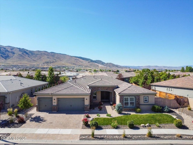 9740 Cardigan Bay Ln, Reno, NV 89521 - single story home with an attached garage, a tile roof, decorative driveway, a mountain view, and stucco siding