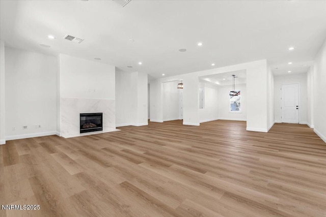 9740 Cardigan Bay Ln, Reno, NV 89521 - unfurnished living room with recessed lighting, light wood finished floors, and a premium fireplace