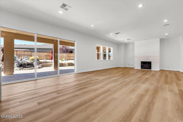 9740 Cardigan Bay Ln, Reno, NV 89521 - unfurnished living room featuring healthy amount of natural light, light wood-type flooring, recessed lighting, and a high end fireplace