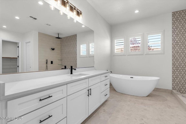 9740 Cardigan Bay Ln, Reno, NV 89521 - full bathroom with vanity, tiled shower, a freestanding bath, and recessed lighting
