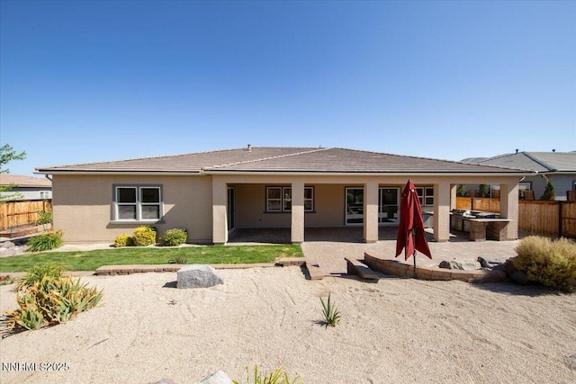9740 Cardigan Bay Ln, Reno, NV 89521 - back of house with a fenced backyard, a patio area, and stucco siding