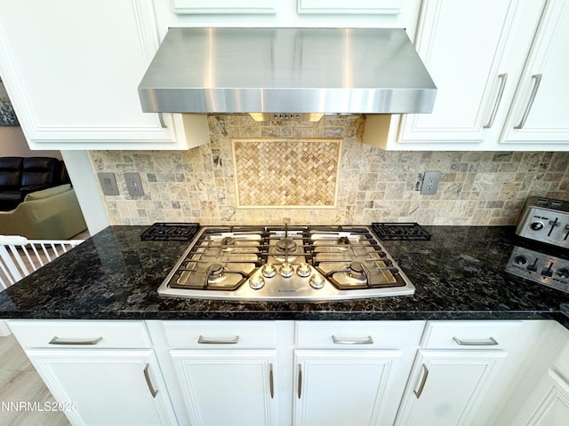 6726 Runnymede Dr, Sparks, NV 89436 - kitchen with exhaust hood, stainless steel gas stovetop, white cabinetry, decorative backsplash, and dark stone countertops