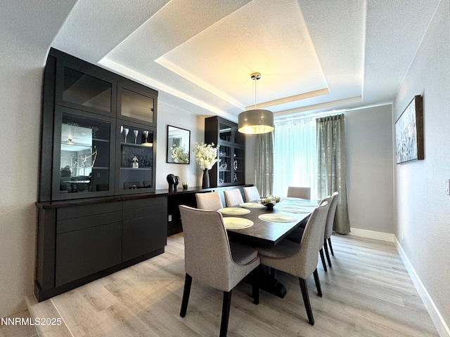 6726 Runnymede Dr, Sparks, NV 89436 - dining space with a raised ceiling, light wood-type flooring, and baseboards
