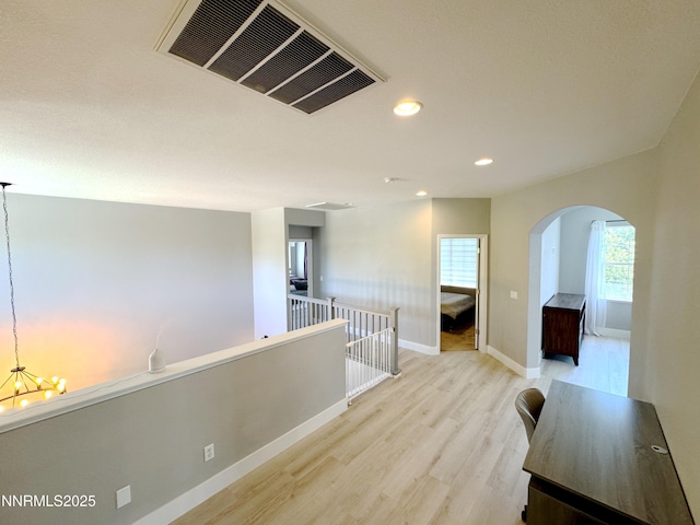 6726 Runnymede Dr, Sparks, NV 89436 - hall with arched walkways, light wood-style flooring, recessed lighting, baseboards, and a chandelier