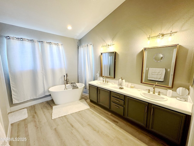 6726 Runnymede Dr, Sparks, NV 89436 - bathroom with wood finished floors, double vanity, a freestanding bath, and lofted ceiling
