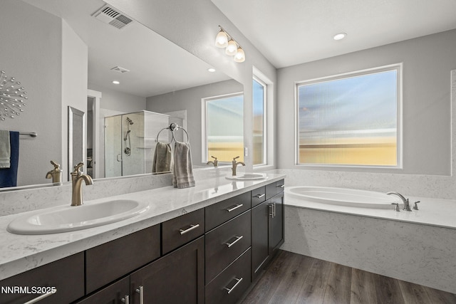 1661 Buttonwillow St, Minden, NV 89423 - bathroom featuring a garden tub, double vanity, a shower stall, and wood finished floors