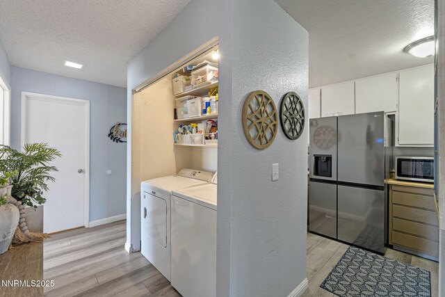 11050 Zeolite Dr, Reno, NV 89506 - laundry area featuring washer and clothes dryer, a textured ceiling, light wood-style flooring, baseboards, and a textured wall