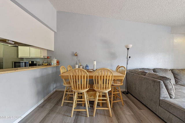 11050 Zeolite Dr, Reno, NV 89506 - dining space featuring wood finished floors, a textured ceiling, and baseboards