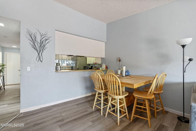 11050 Zeolite Dr, Reno, NV 89506 - dining area with wood finished floors, baseboards, and a textured ceiling
