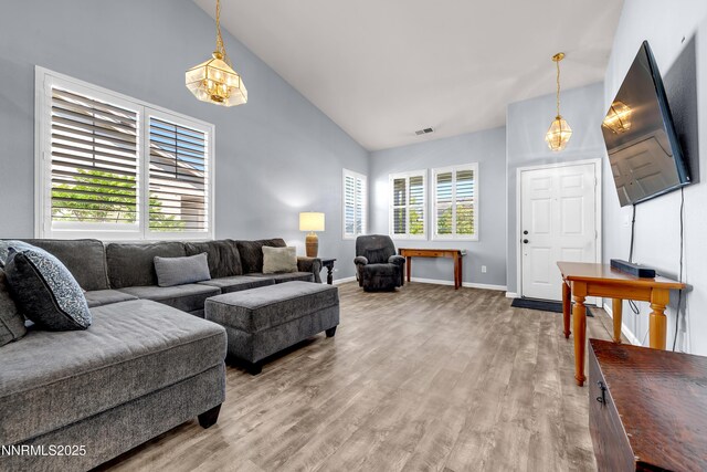 8975 Sorcha St, Reno, NV 89506 - living room with light wood finished floors, baseboards, high vaulted ceiling, and a chandelier