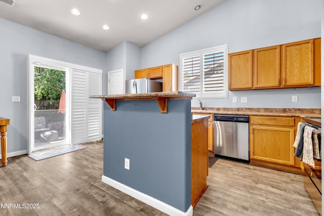 8975 Sorcha St, Reno, NV 89506 - kitchen with stainless steel appliances, light wood-style flooring, recessed lighting, a breakfast bar, and a center island