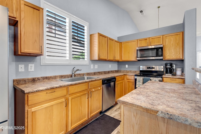 8975 Sorcha St, Reno, NV 89506 - kitchen with appliances with stainless steel finishes, a sink, vaulted ceiling, light wood-style floors, and light countertops