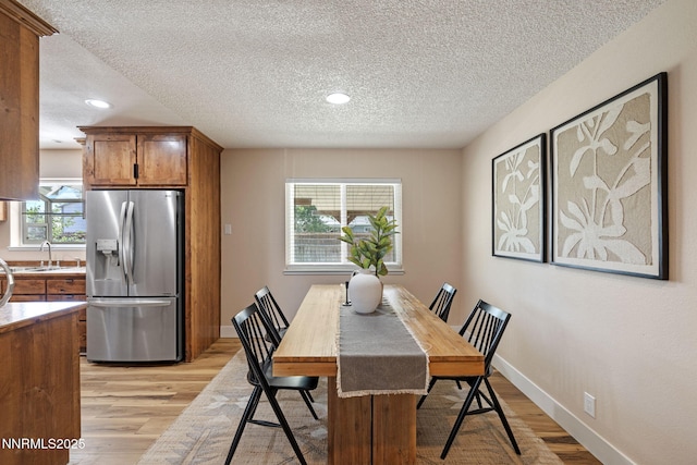 295 Sandia Dr, Fernley, NV 89408 - dining space featuring a textured ceiling, light wood-style floors, recessed lighting, and baseboards