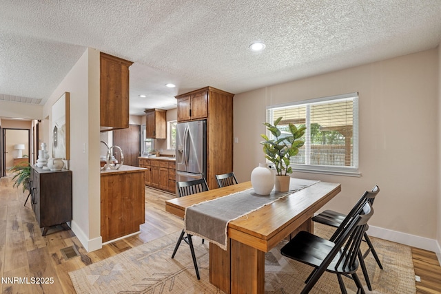 295 Sandia Dr, Fernley, NV 89408 - dining area with light wood-style floors, a textured ceiling, healthy amount of natural light, recessed lighting, and baseboards