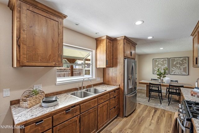 295 Sandia Dr, Fernley, NV 89408 - kitchen with a sink, appliances with stainless steel finishes, light wood-style floors, light countertops, and brown cabinetry